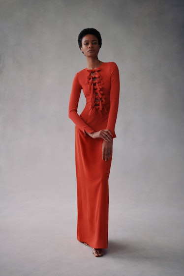 A model in a floor-length red dress by Oscar de la Renta