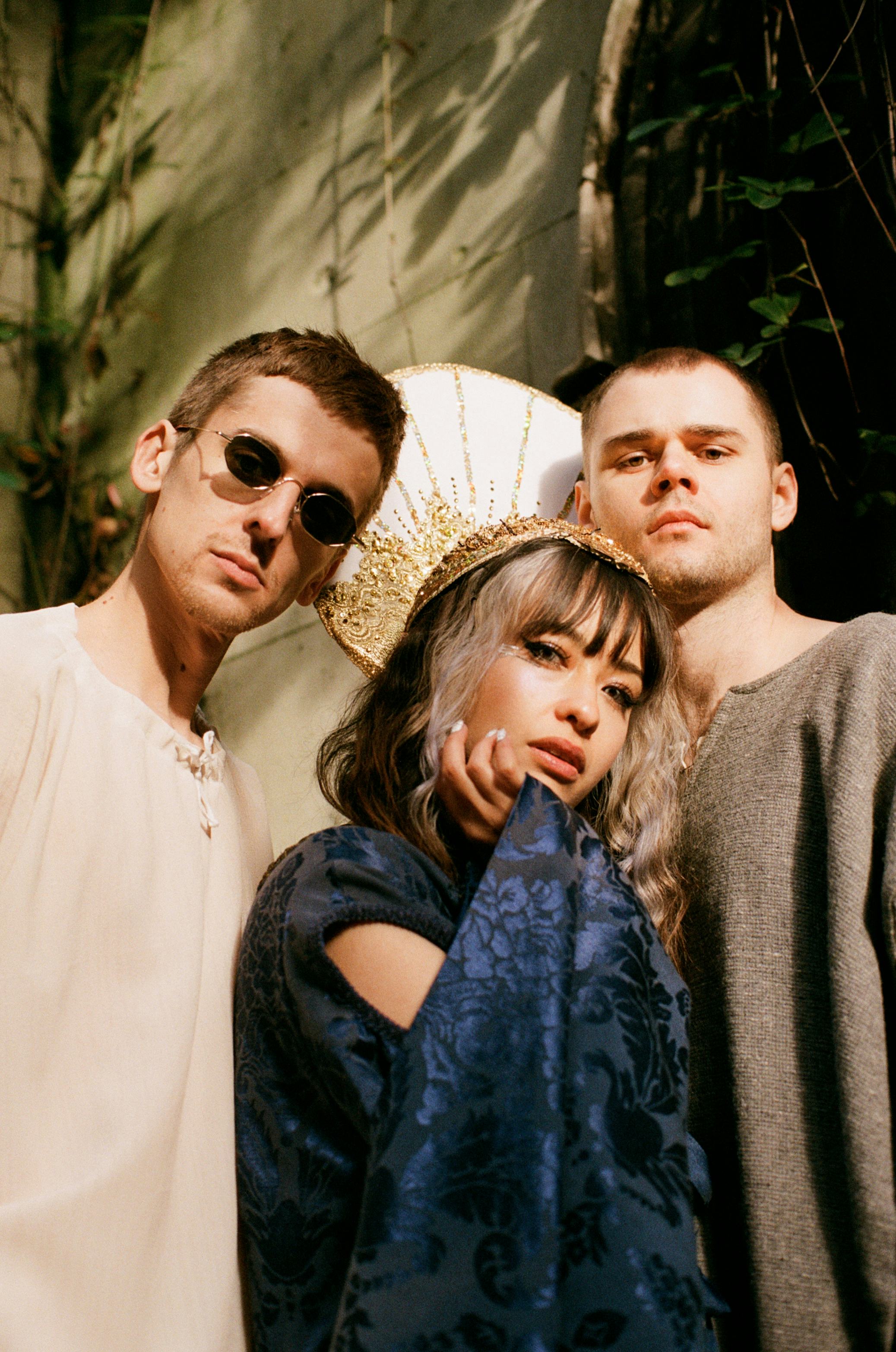 A portrait of band Kero Kero Bonito. Band members Sarah Bonito, Gus Lobban, Jamie Bulled stand again...