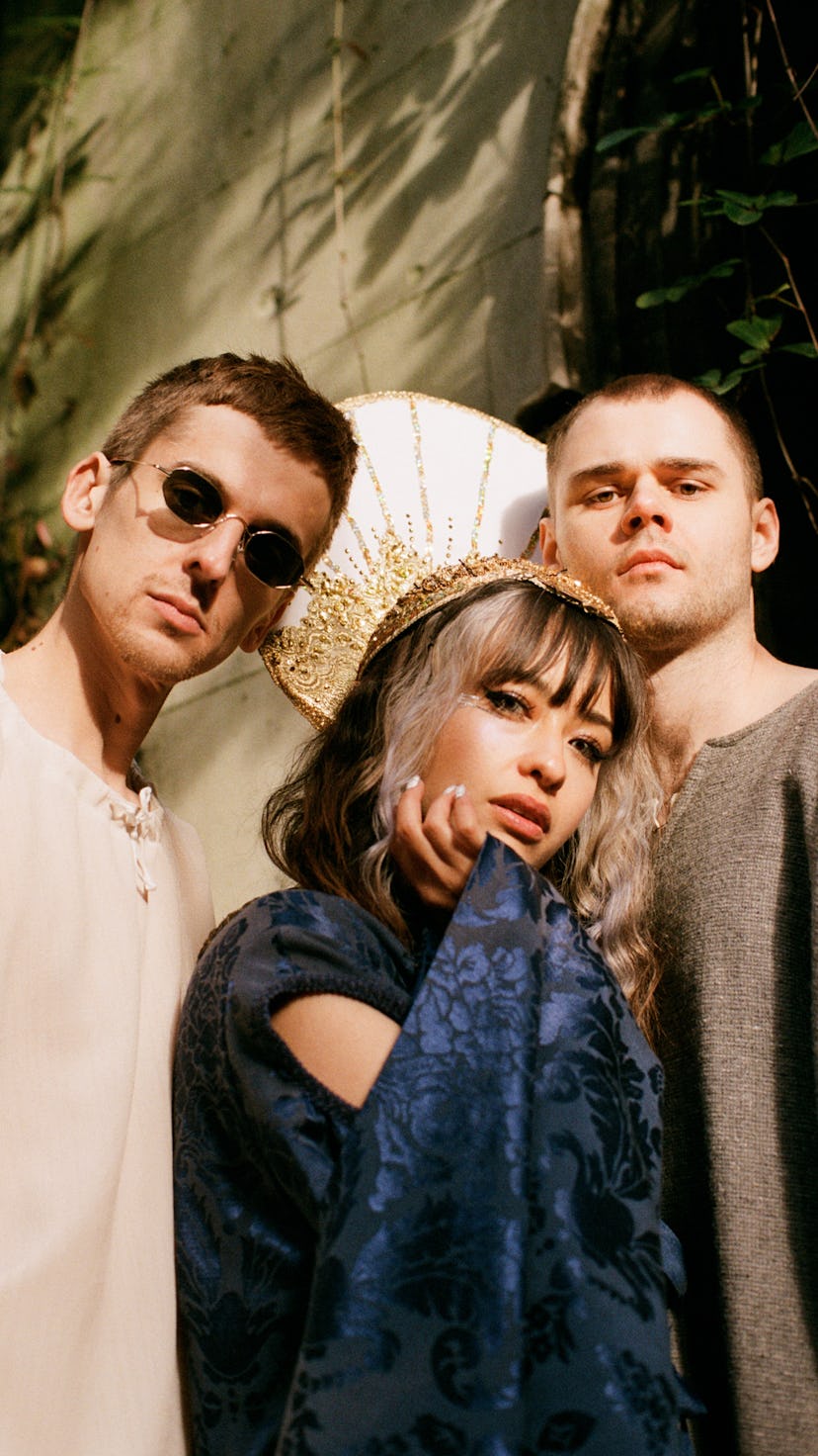 A portrait of band Kero Kero Bonito. Band members Sarah Bonito, Gus Lobban, Jamie Bulled stand again...