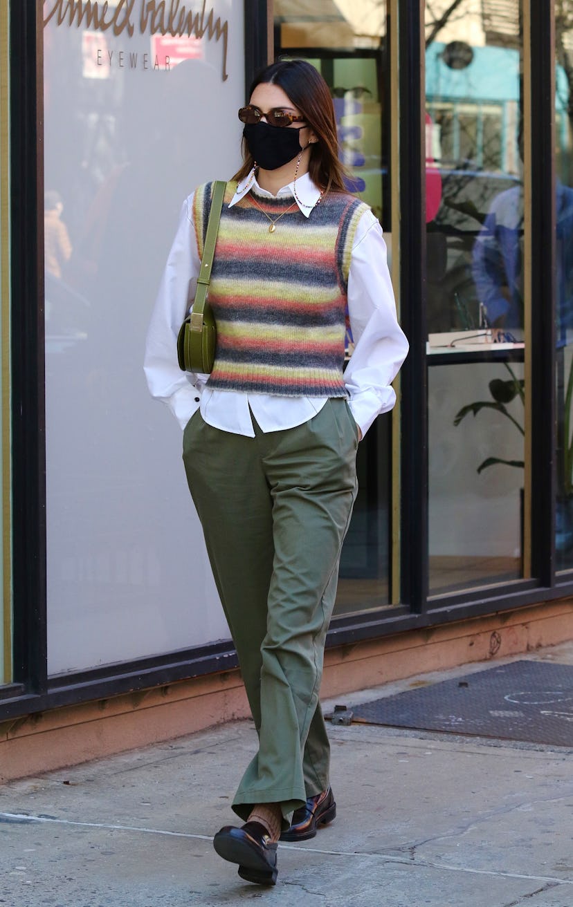 Kendall Jenner in a white shirt, a striped knit waistcoat and khaki pants in a '70s Menswear look