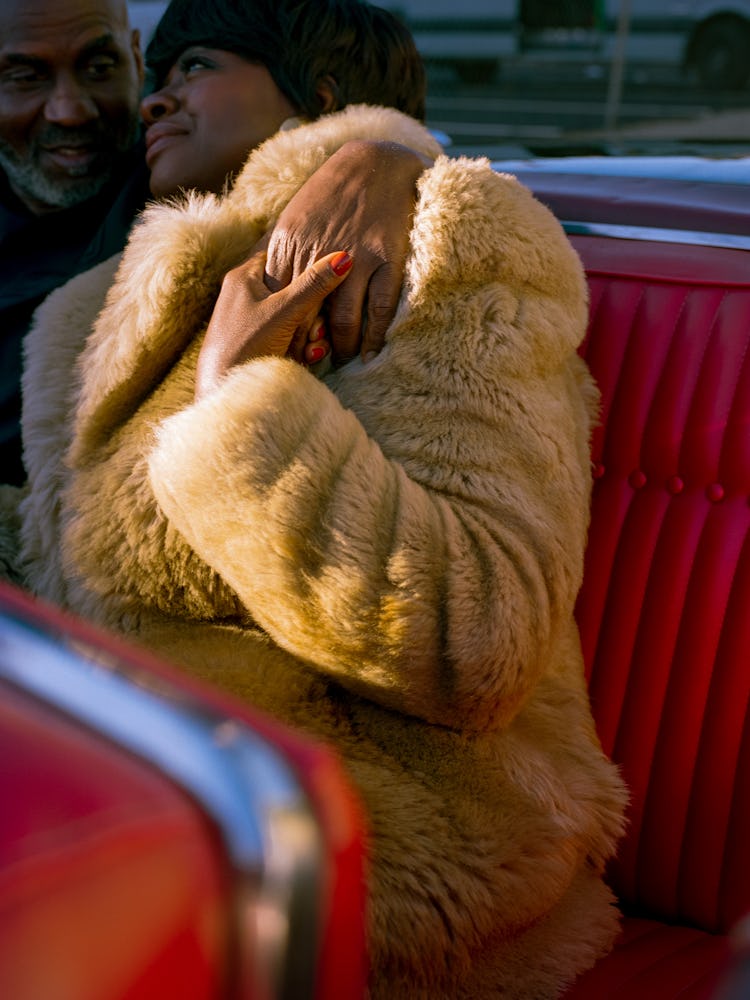 Viola Davis leaning in Julius Tennon’s arms, wearing a fur coat