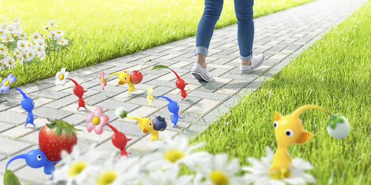 A person walking down a pedestrian and red, yellow and blue characters from the game Pikmin followin...