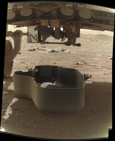 A picture of the Ingenuity helicopter tucked inside the Perseverance rover on the surface of Mars.