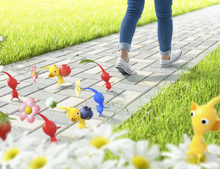 A person walking down a pedestrian and red, yellow and blue characters from the game Pikmin followin...