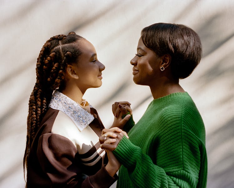 Viola Davis and her daughter Genesis Tennon holding hands and looking at each other while smiling