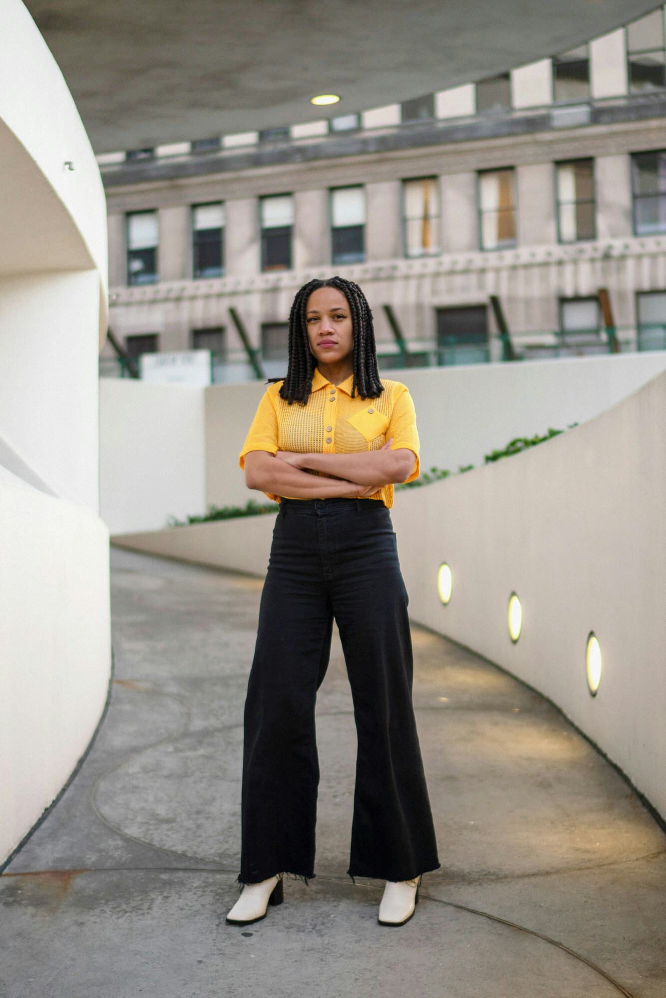Ashley James standing arms crossed in front of Guggenheim