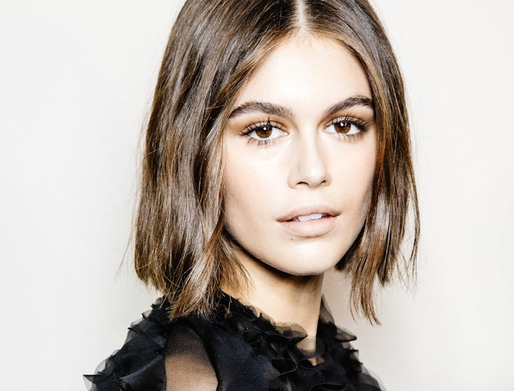 Kaia Gerber wearing a sheer black blouse