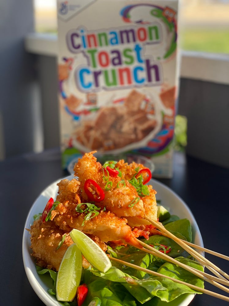 A plate of Cinnamon Toast Crunch tempura shrimp sits on a table in front of a box of Cinnamon Toast ...