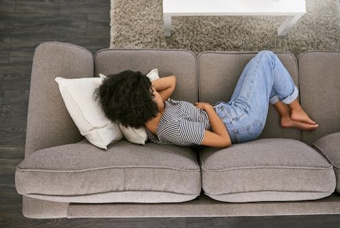 Woman in pain on the sofa.