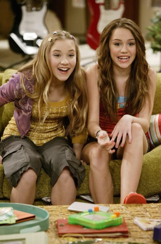 Miley and Lily sit on the couch and react to the TV during an episode of 'Hannah Montana'.