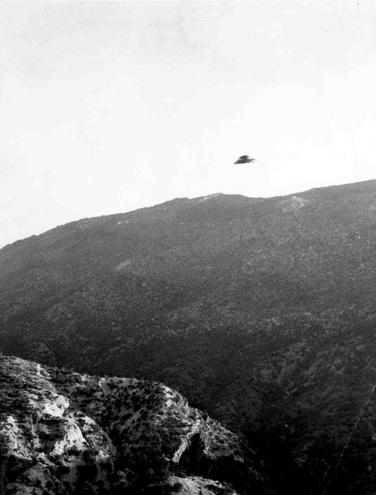 A UFO over a large hill