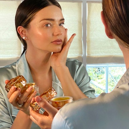Miranda Kerr putting her glow moisturizer on her face