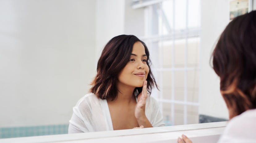 woman looking in her bathroom mirror