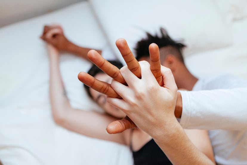 couple spooning in bed, holding hands