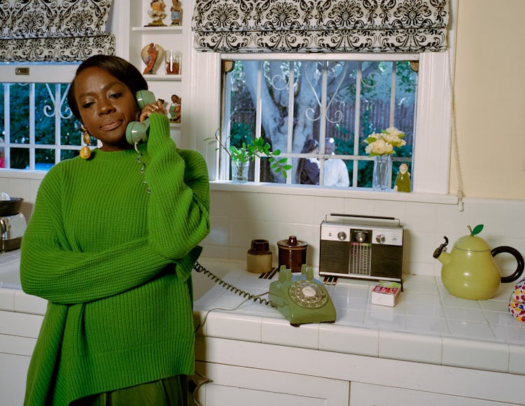 Viola Davis talking on the retro green telephone while leaning on the kitchen counter