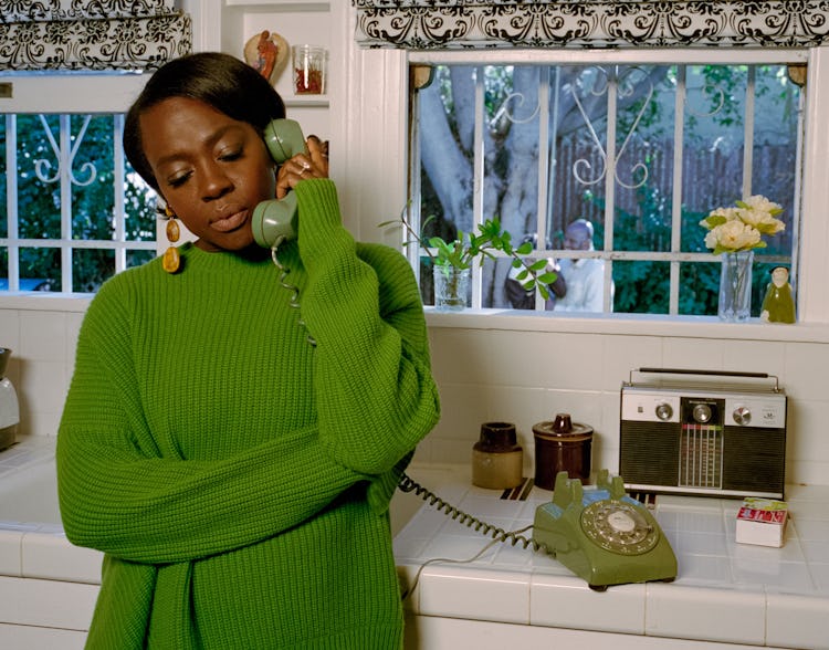 Viola Davis talking on the retro green telephone leaning on the kitchen counter