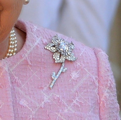 Get to know the stories behind Queen Elizabeth's most memorable brooches, from her palm leaf brooch ...