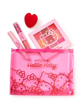 HipDot x Hello Kitty collection pink bag, with products including makeup sponge and palette spilling...