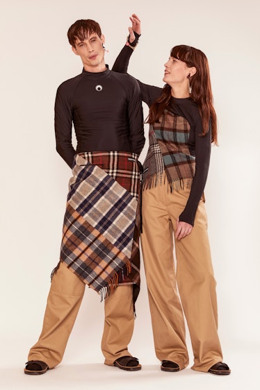 A male and female model in black shirt and beige pants with plaid elements by Marine Serre