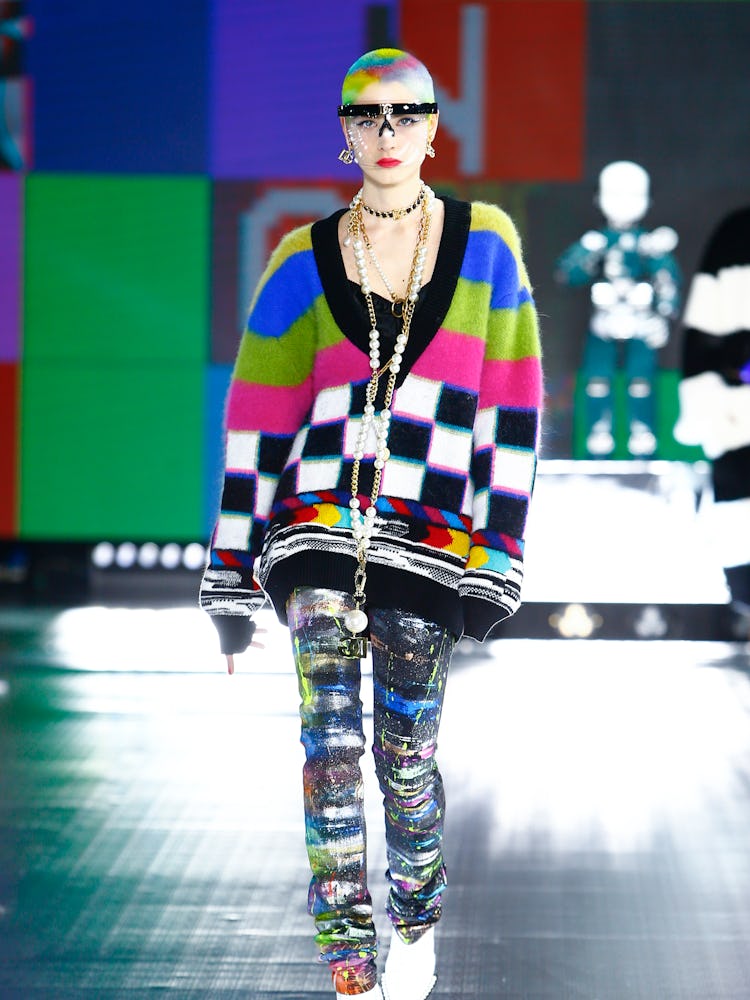 A model in a multi-color knit sweater and multi-colored pants at Dolce & Gabbana's Fall 2021 Runway
