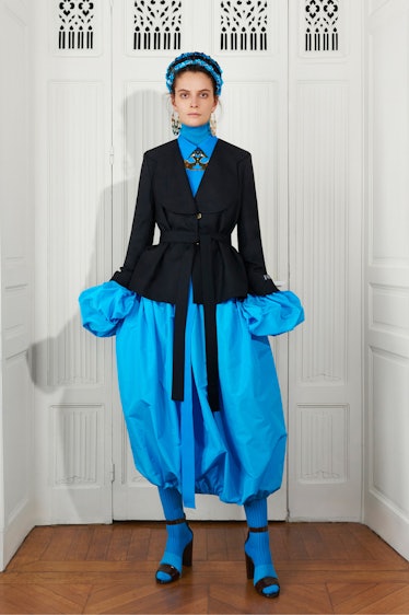 A model in a black blazer and blue button-up with matching puffy pants by Patou