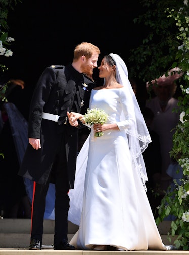 Meghan Markle in a white wedding dress and veil and Prince Harry in a black suit