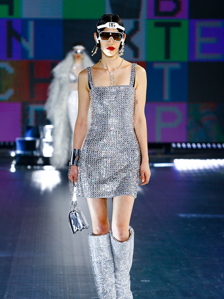 A model wearing a matching silver shimmery dress and boots at Dolce & Gabbana's Fall 2021 Runway