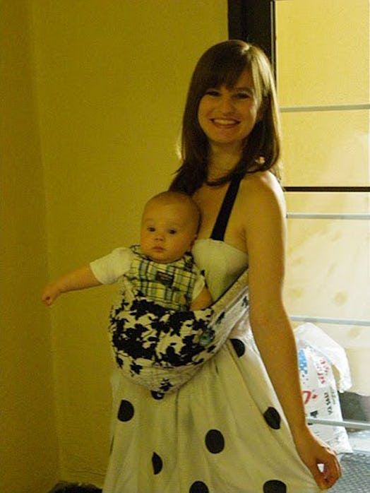 A woman carrying her baby with a carrier on her chest
