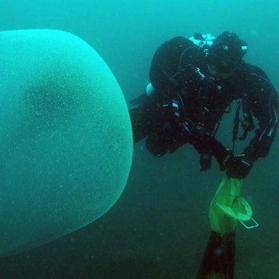 diver examines giant sphere underwater