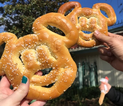 Friends hold up their Mickey pretzels and churros at Disneyland. 