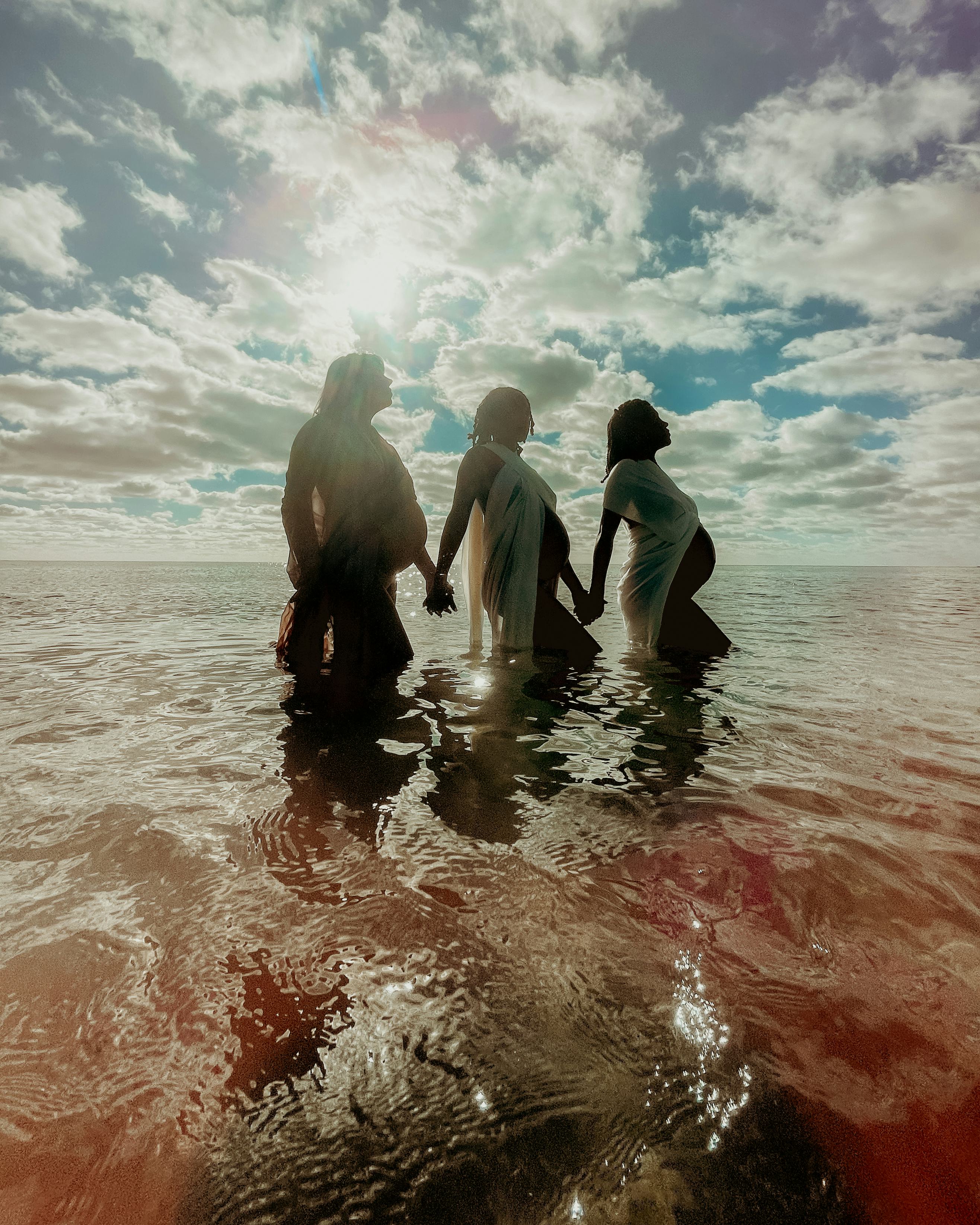Three pregnant women in the water. Apple partnered with female photographers for an International Wo...