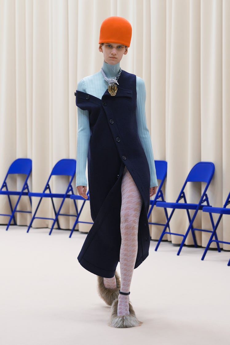A model in a blue turtleneck, denim dress, light pink tights and furry shoes by Nina Ricci