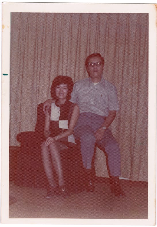 Old picture, from 1960s, of a Taiwanese couple, with woman sitting on a sofa, and her man sitting on...