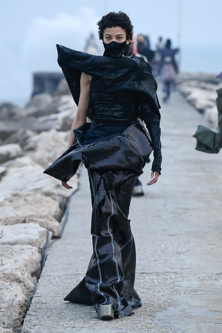 A model in a black dress, silver chunky heels and a black face mask all by Rick Owens 