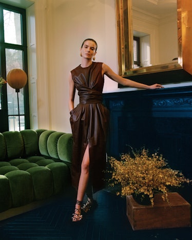 A model in a leather dress and strappy sandals by Altuzarra