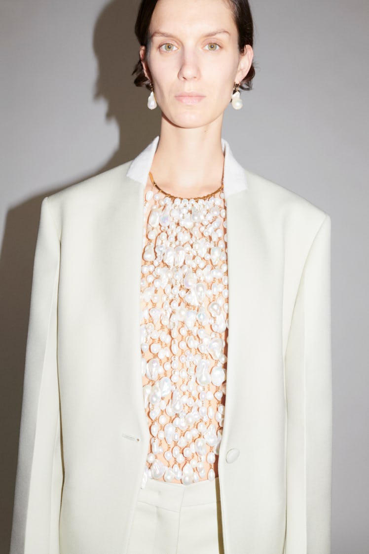 A model in a white suit and pearl blouse by Jil Sander