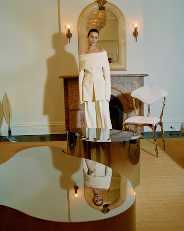 A model in a beige off-the-shoulder top and wide pants by Altuzarra