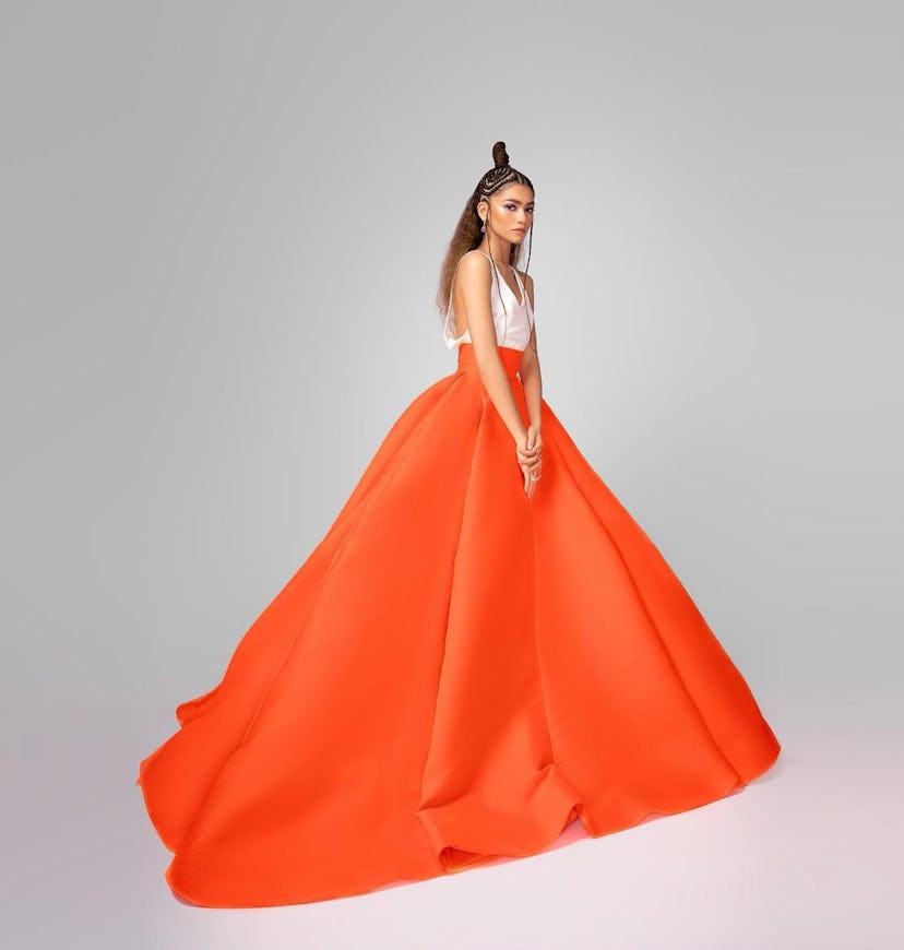 Zendaya posing in a large orange dress
