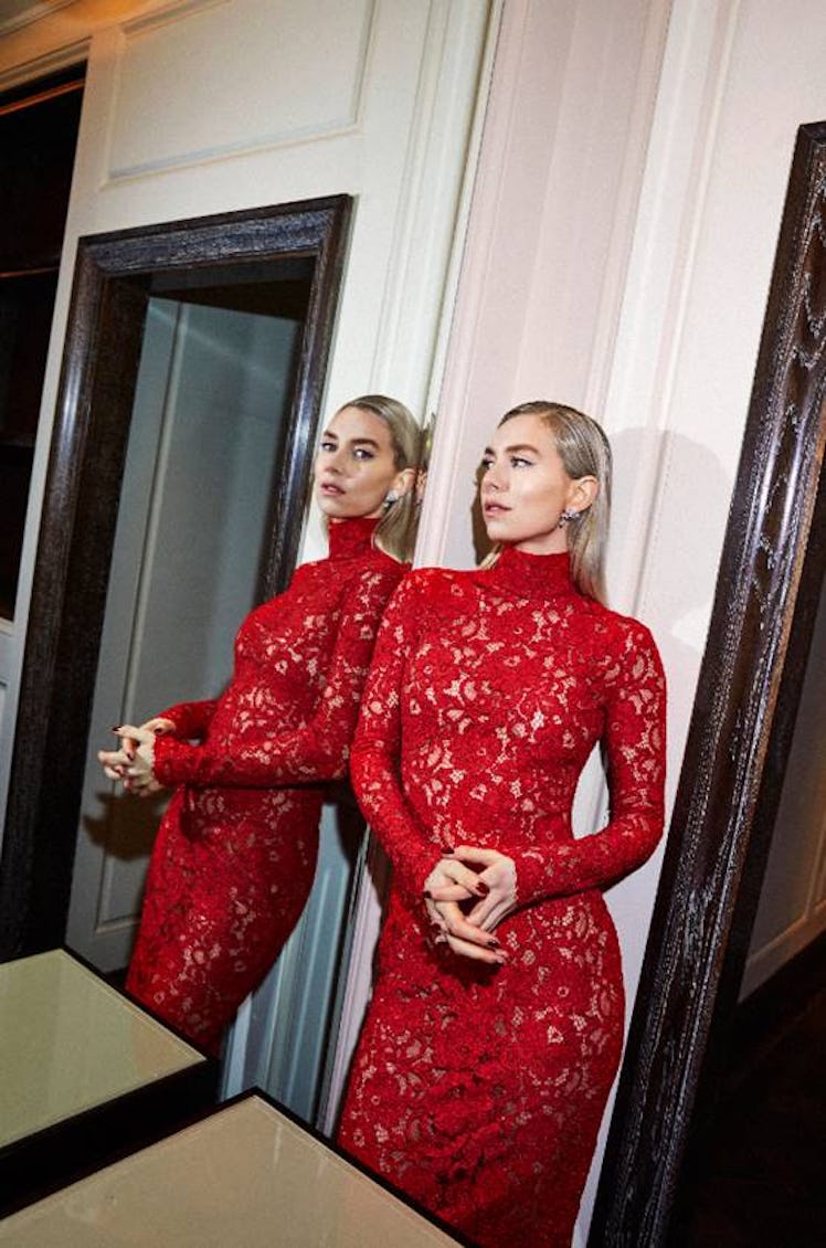Vanessa Kirby posing next to a mirror in a red Saint Laurent dress