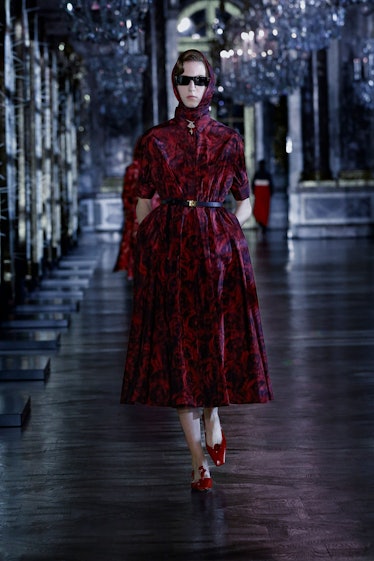 A model in a maroon gown with black sunglasses by Dior 