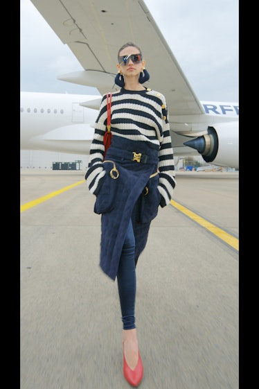 A model in a blue and white striped sweater, jeans and a blue skirt by Balmain 
