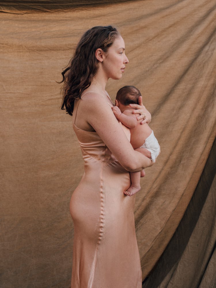 Nicole Stark holding her son in a diaper to her chest 