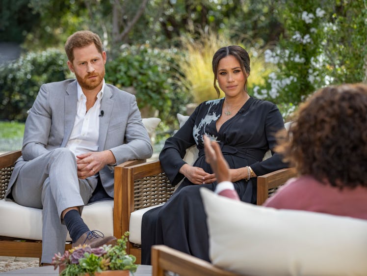 Prince Harry and Meghan Markle listen as Oprah Winfrey asks them a question.