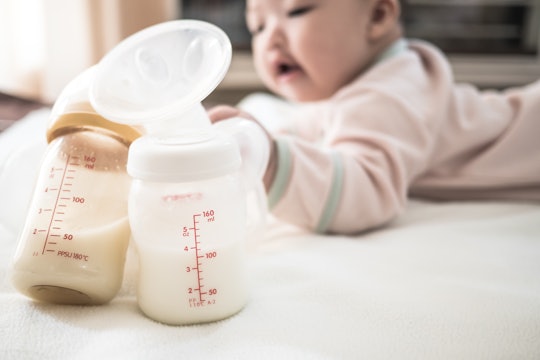 bottles of breast milk next to a baby 