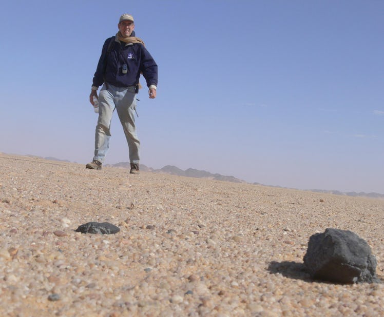 A man in the desert with some rocks in the foreground