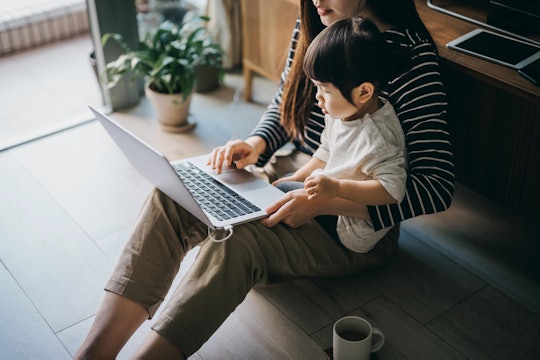 mom working on computer with toddler in her lap