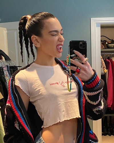 Dua Lipa in a mirror selfie that features her beaded phone charm