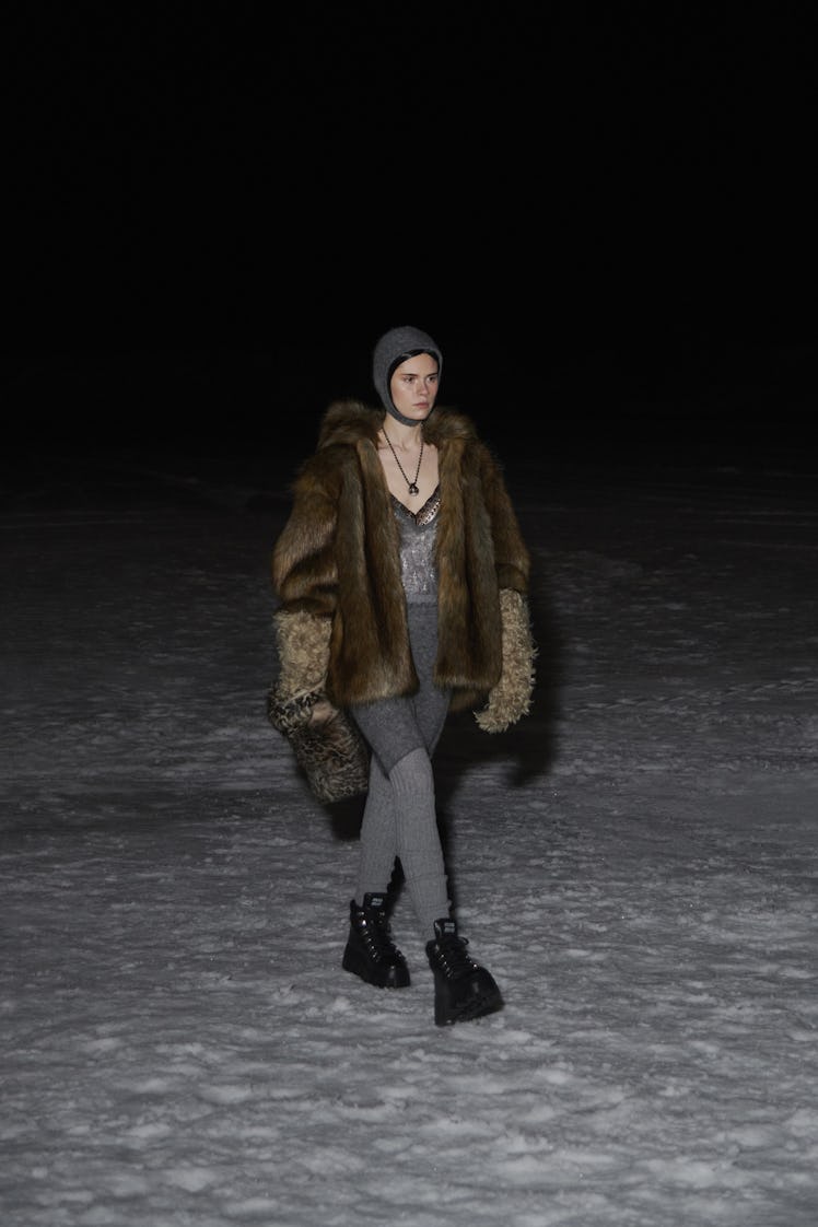 A model in a brown fur coat, grey hat and grey pants by Miu Miu 