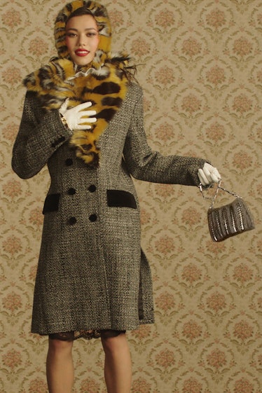 A model in a long grey jacket with a tiger-print head scarf by Paco Rabanne 