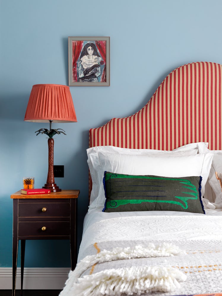 A bedroom Heuman designed for a client’s pied-a-terre in London with a striped headboard 